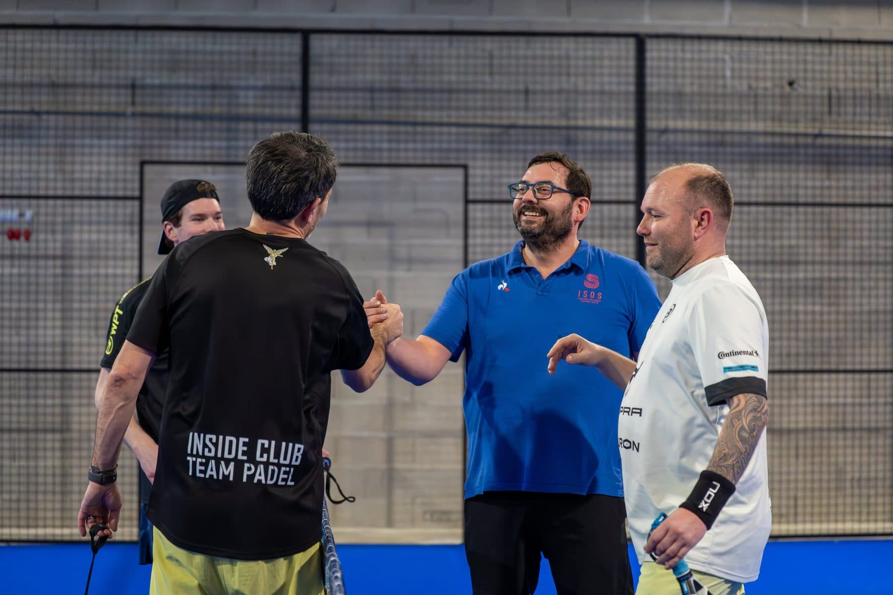 Inside Club Team Padel players greeting each other on a court in Reims