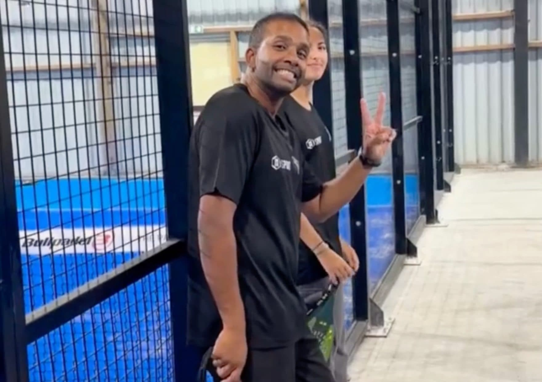Participants souriants au bord d'un court de padel lors d'un team building