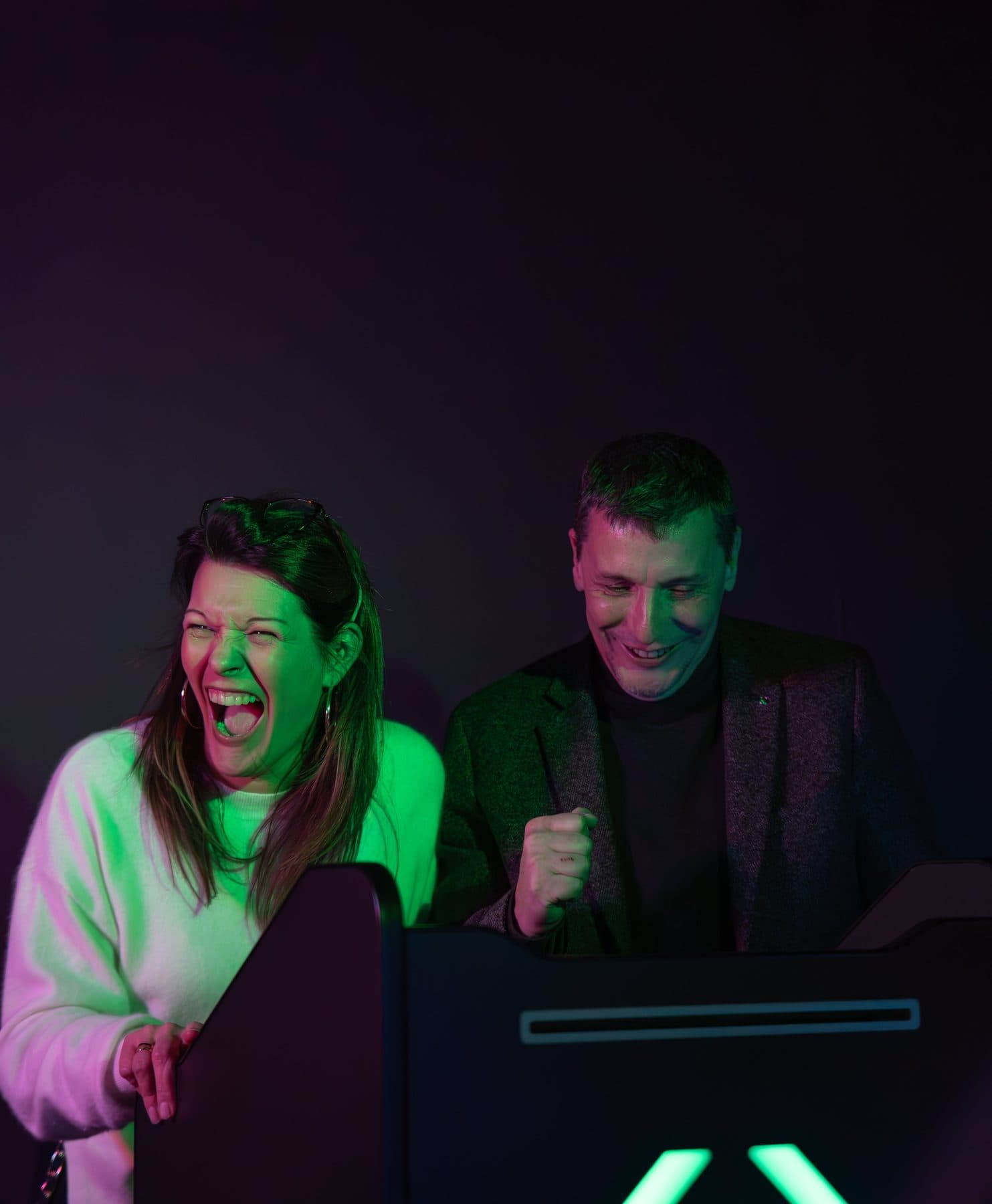 Deux joueurs riant devant un pupitre de quiz