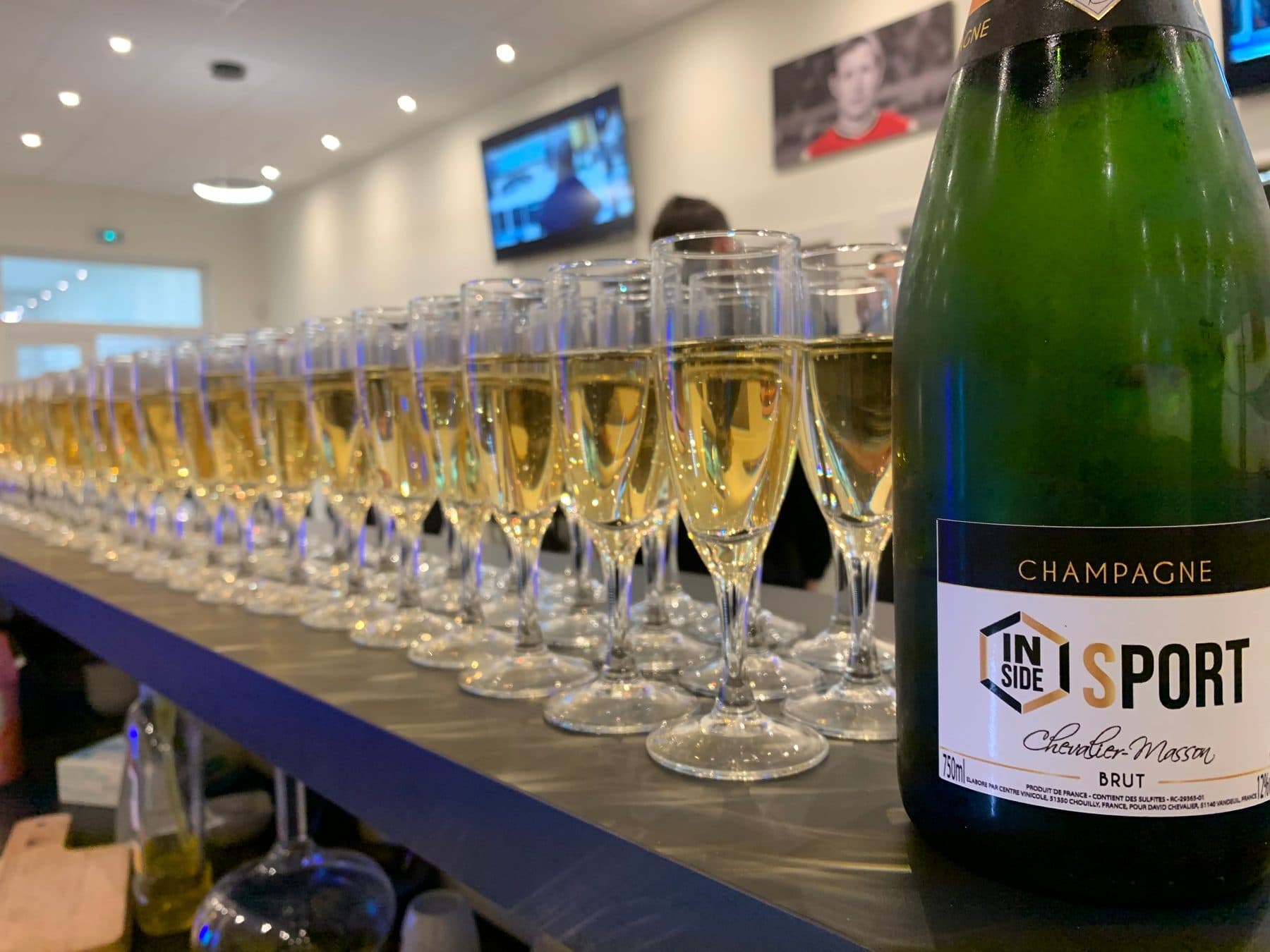 Coupes de champagne alignées au bar d'Inside Sport Reims
