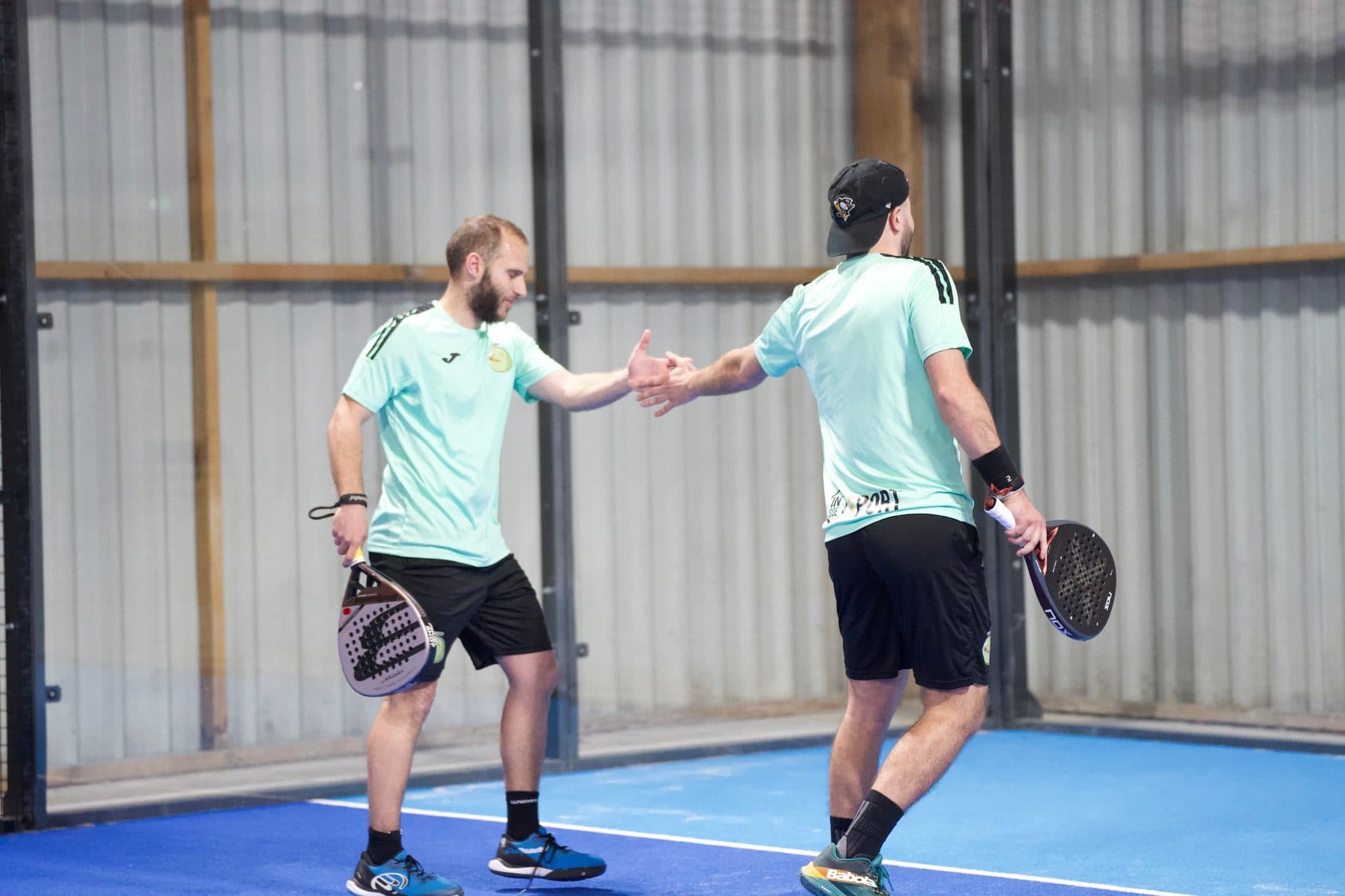 Deux joueurs de padel se saluent sur une piste d'Inside Sport