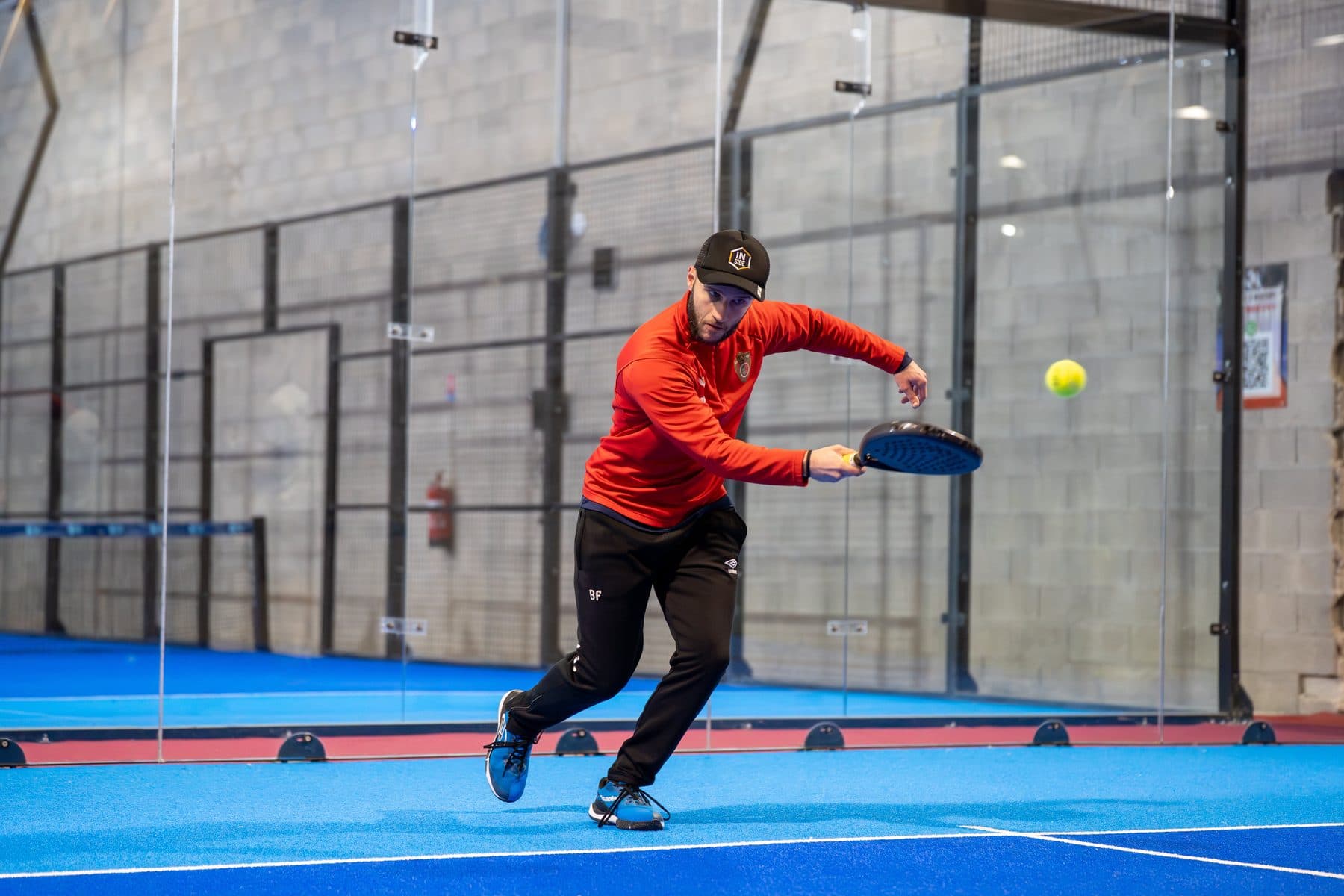 Padel-Spieler in Aktion auf einem blauen Court