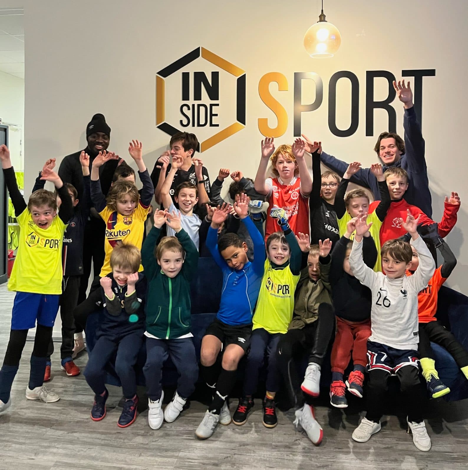 Camp children posing in front of the Inside Sport logo with guest players